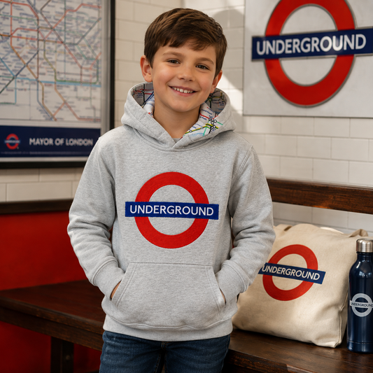 Child wearing a grey London Underground hoodie in an indoor London-style setting