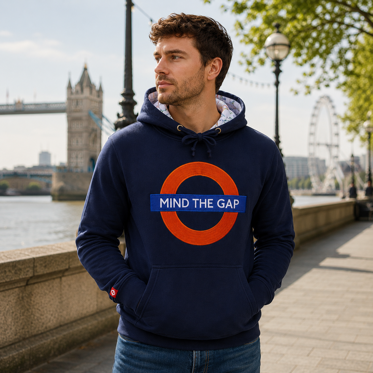 Man wearing a navy hoodie with a 'Mind the Gap' design in London.
