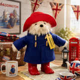 Official Paddington Bear Large Collector Plush displayed in a cosy British-themed room with vintage travel décor and Union Jack accents.