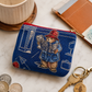 Blue coin purse with Paddington Bear design on a marble surface with coins and keys.