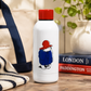 White water bottle with red lid and Paddington Bear illustration on a wooden surface.
