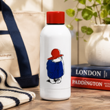 White water bottle with red lid and Paddington Bear illustration on a wooden surface.