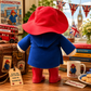 Rear view of the Official Large Collector Paddington Bear plush on a white background showing the hooded duffle coat and iconic red hat.