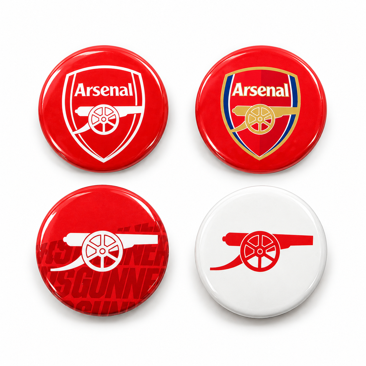 Four round Arsenal-themed button badges arranged in a 2x2 grid on a white background. Two badges are red with white Arsenal logos, one shows a white cannon on a red background, and one is red with a white cannon and Arsenal text.