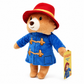 Side view of the Official Paddington Bear plush showcasing the classic blue duffle coat, red hat and branded swing tag on a clean white background.