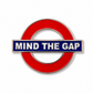 Mind the Gap metal enamel fridge magnet with London landmarks in the background