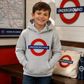 Child wearing a grey London Underground hoodie in an indoor London-style setting