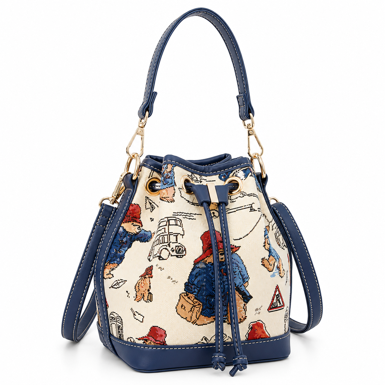 Cream Paddington Bear print bucket bag with navy trim, drawstring closure, gold-tone hardware and detachable straps.