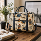 Paddington Bear print laptop bag displayed on a wooden desk beside a coffee cup, glasses, book and framed London photograph.