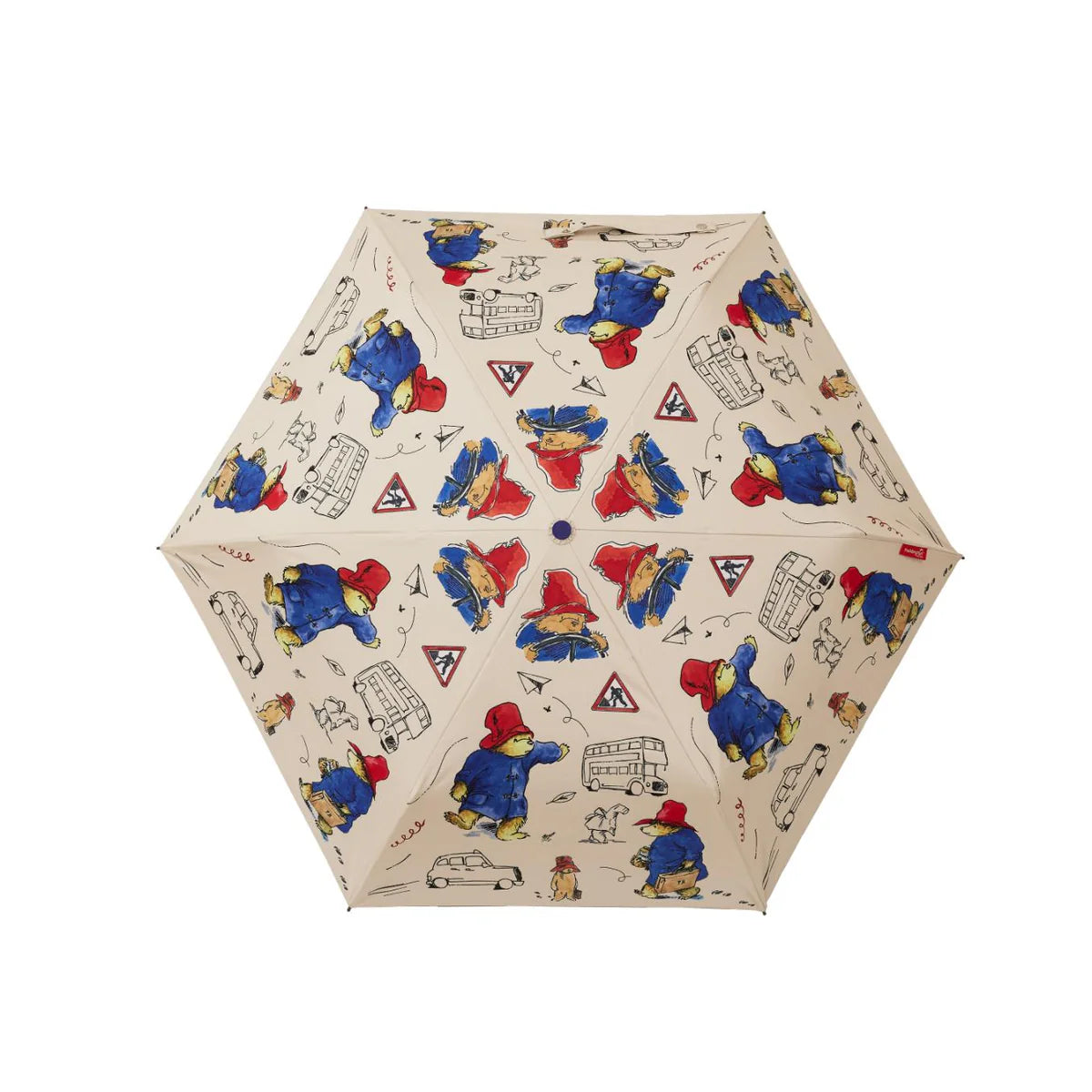 Open cream umbrella featuring colourful Paddington Bear illustrations, London buses, cars and road signs