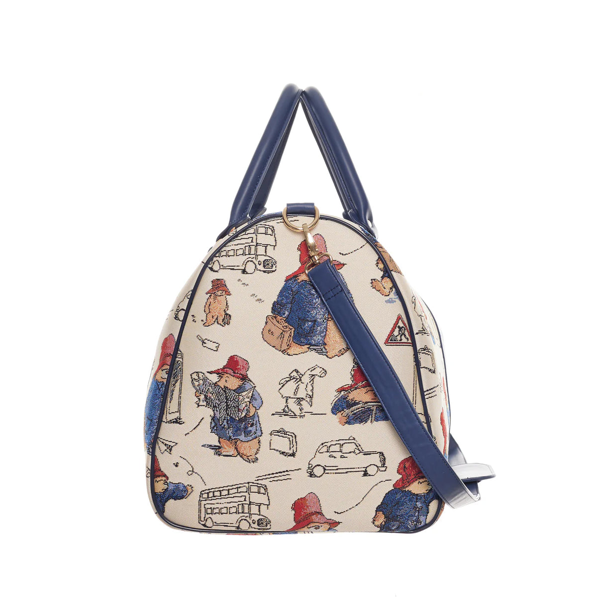 Side view of the cream Paddington Bear print travel bag showing navy trim, handles and detachable shoulder strap.